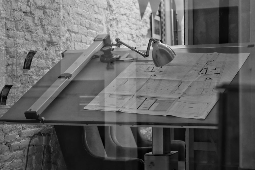 Table à dessin d'architecte avec un plan et une lampe articulée